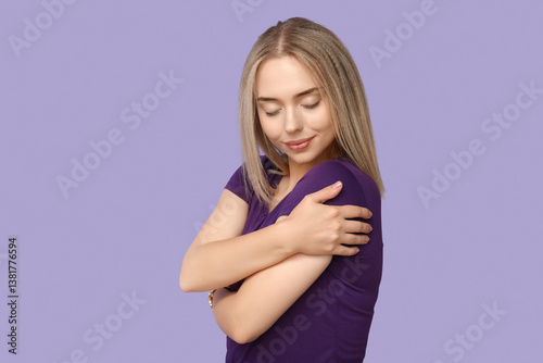 Young woman hugging herself...