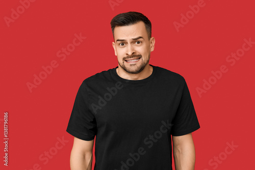 Papier peint Handsome ashamed young man on red background