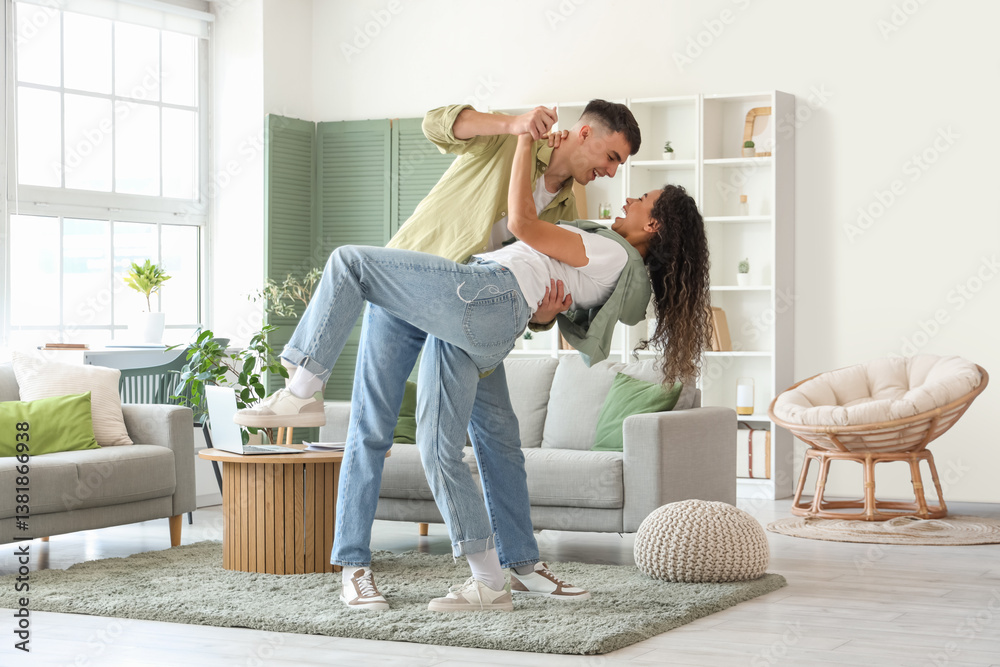 Happy young beautiful couple dancing at home