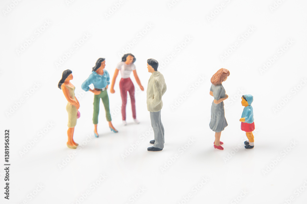 Two groups of colorful miniature figurines, including adults and a child with a ball, stand apart on a reflective white surface, symbolizing social distancing, family, or community dynamics. Two groups of colorful miniature figurines, including adults and a child with a ball, stand apart on a reflective white surface, symbolizing social distancing, family, or community dynamics.