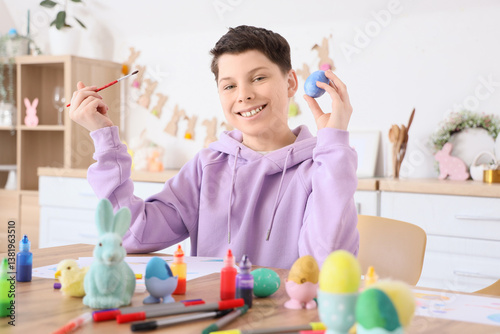 Teenage boy painting Easter...