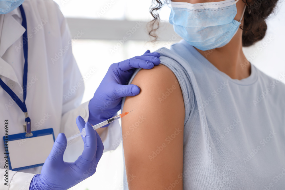 Naklejka premium Female doctor vaccinating young woman in clinic, closeup