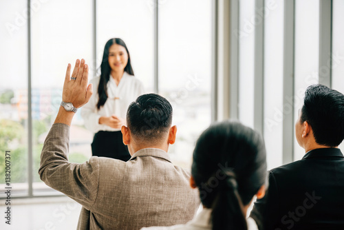 Obraz na płótnie Active engagement is on display as a large group in a seminar classroom raises their hands to participate in the discussion