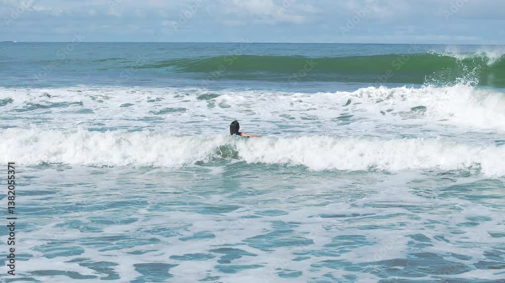 A beautiful girl enjoys surfing in the captivating and stunning waves of Costa Rica. This moment was captured in slow motion to provide an immersive experience for viewers and enthusiasts alike A beautiful girl enjoys surfing in the captivating and stunning waves of Costa Rica. This moment was captured in slow motion to provide an immersive experience for viewers and enthusiasts alike