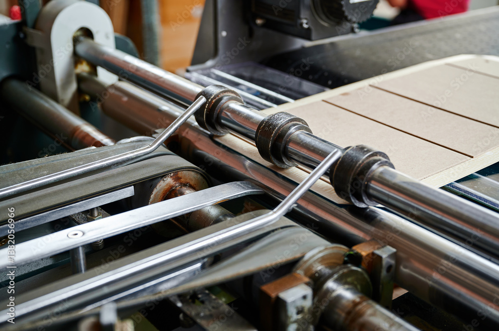 Fototapeta premium Innovative machine efficiently folds cardboard box flaps for streamlined packaging processes in a busy workshop