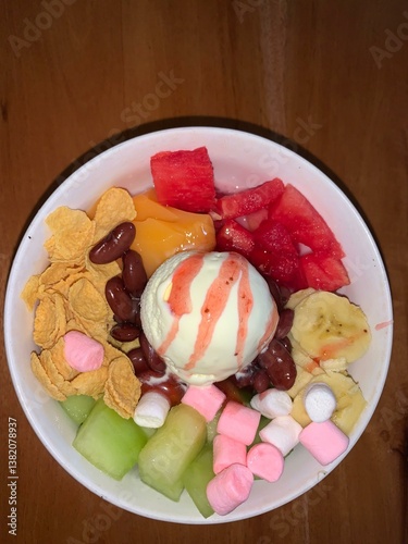 a bowl of ice cream with fruit, nut, and marshmallow toppings
