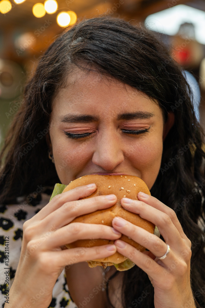 Close-up shot of happy woman with closed eyes taking big bite of delicious burger. Hands holding food, pure enjoyment moment. Authentic food pleasure.
Close-up shot of happy woman with closed eyes taking big bite of delicious burger. Hands holding food, pure enjoyment moment. Authentic food pleasure.