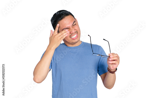 Young Asian man suffering eye discomfort while holding glasses, feeling eye strain or irritation, isolated on transparent background