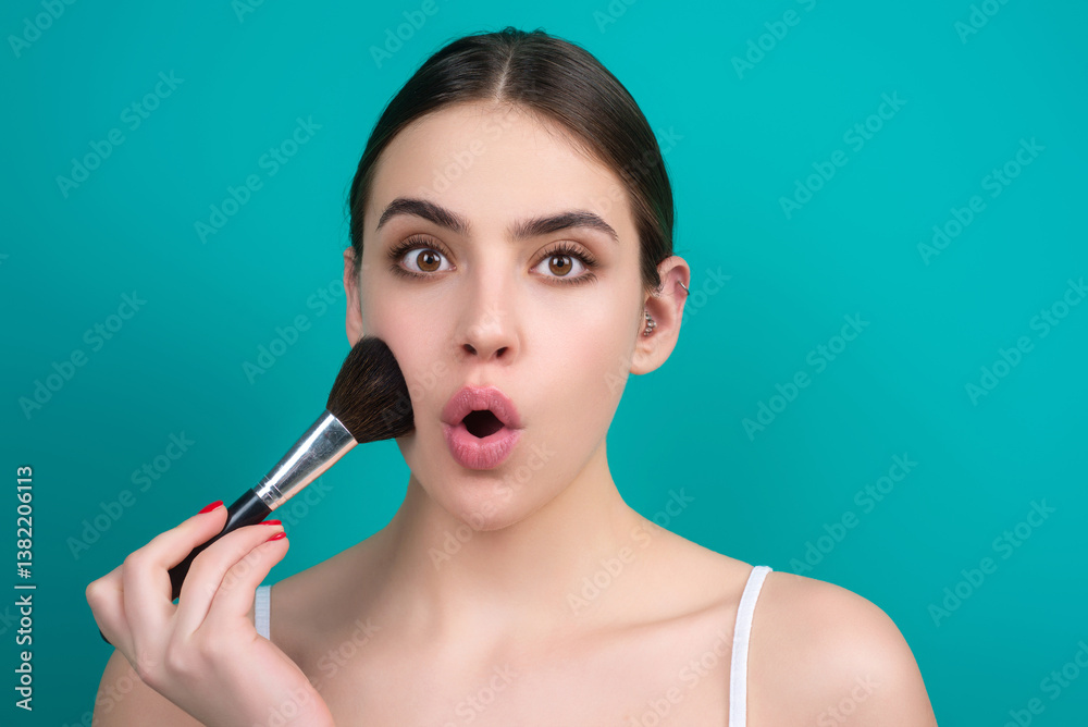 Obraz premium Woman applies powder on the face using makeup brush. Beautiful girl doing contouring apply blush on cheeks. Face beauty cosmetics. Fresh skin and natural make up. Powder blush on facial skin.
