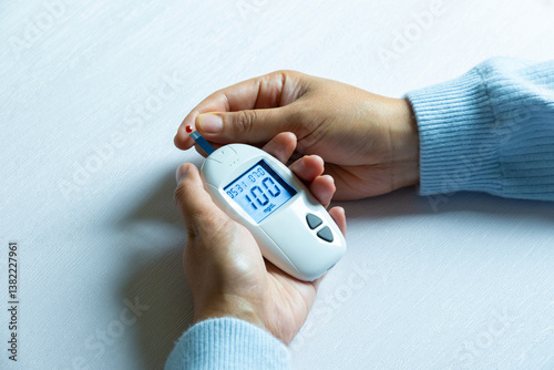 Woman's hands checking diabetes and hyperglycemia with digital blood sugar meter. Healthcare and medical concept	 photo