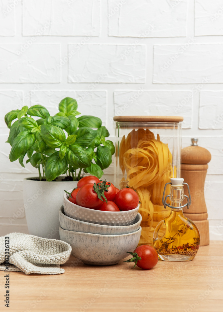 Cherry tomatoes, basil, pasta and olive oil creating an italian culinary scene