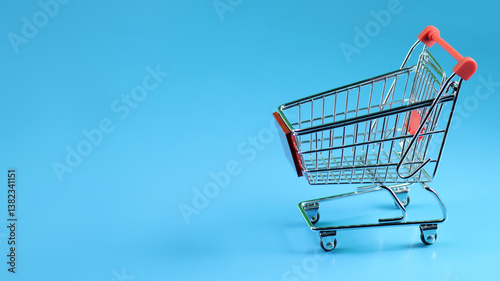 a miniature shopping cart in horizontal blue background