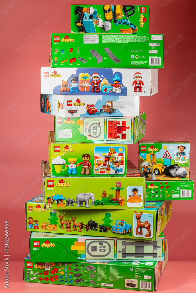 Obraz premium Colorful stack of Lego Duplo toy boxes on pink background