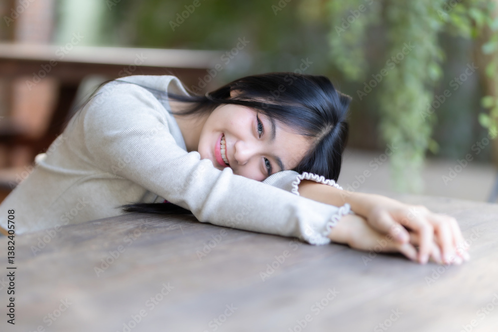 Portrait cute smiles Asian girl putting her hands on table of attractive young teenage girl the cafe on vacation at a coffee shop in spring day