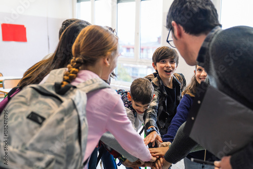 Φωτογραφία Elementary school students and their teacher joining hands together in the class