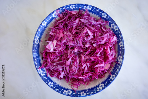 Vibrant red cabbage salad in a bowl. Nutritious, with lemon, olive oil, and sea salt. Rich in vitamins, antioxidants, and heart-healthy benefits. A colorful, healthy dish. photo