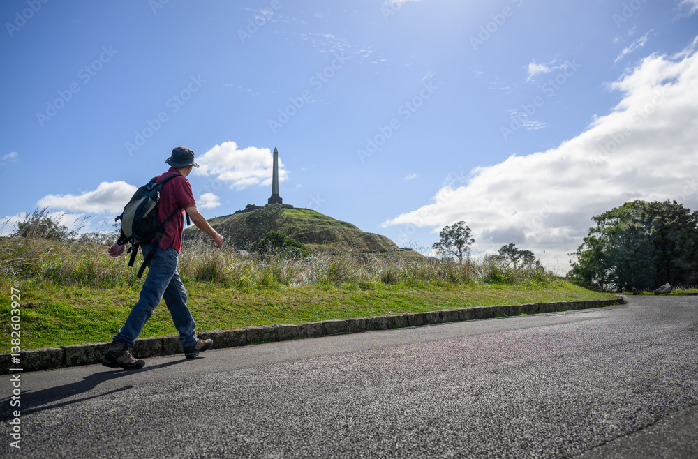 Tourist walking uphill towards the Obelisk. One Tree Hill. Auckland.