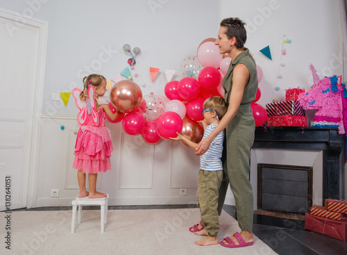 Family enjoys a vibrant, balloon-filled birthday party at home