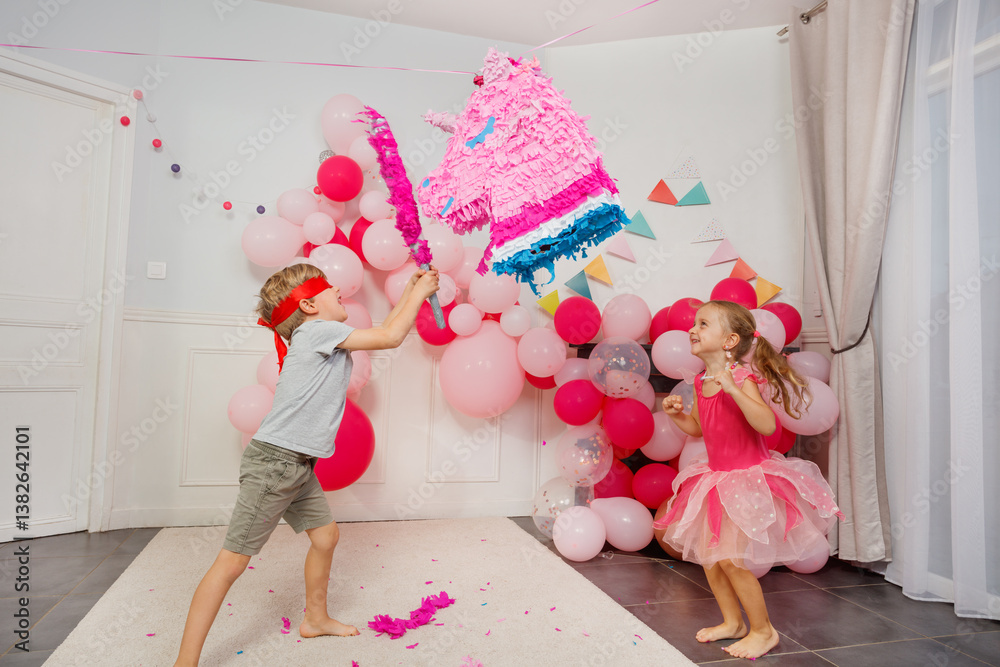 Children laugh and play with a vibrant pinata hitting it hard