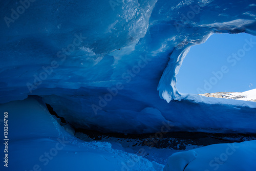 Obraz na płótnie Blue ice cave with bright light seeping through ceiling opening w salonie