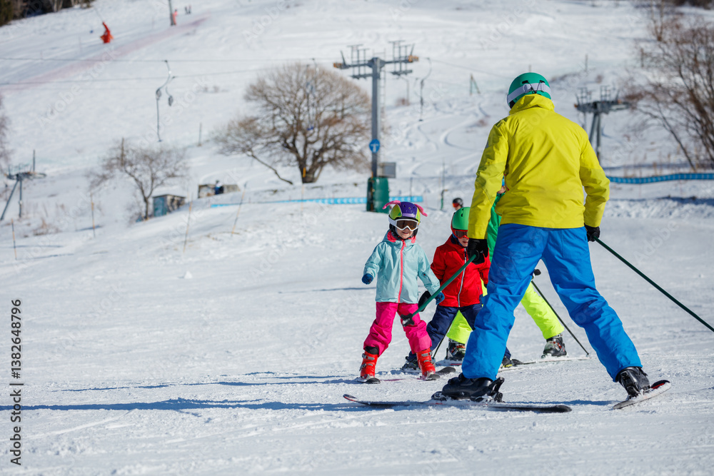 Group of three kids skiing and learning on fresh snow at resort