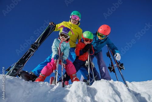 Obraz na płótnie Happy skier family stand on the edge in snowy mountains with ski