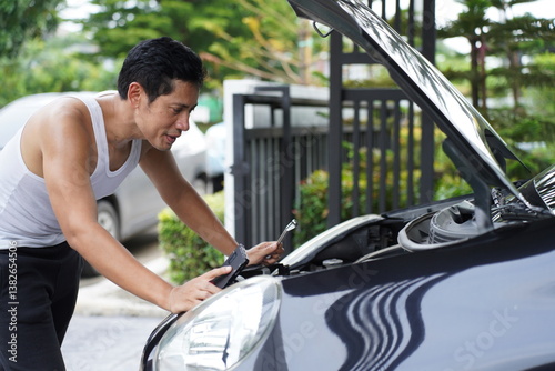 man working on car engine during maintenance photo
