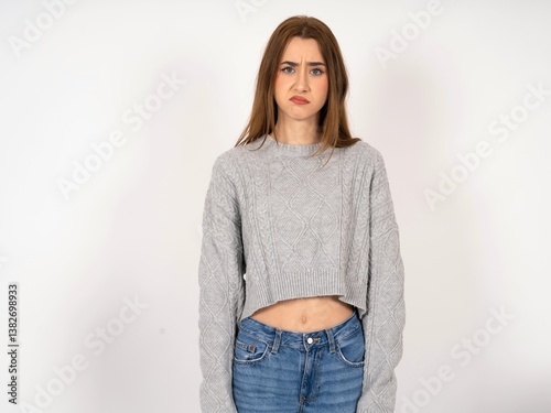 Tableau sur toile Offended dissatisfied Caucasian young girl wearing grey sweater with moody displ