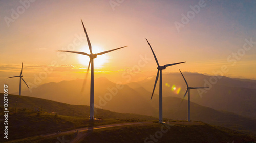 Wind turbines at sunset over hills
