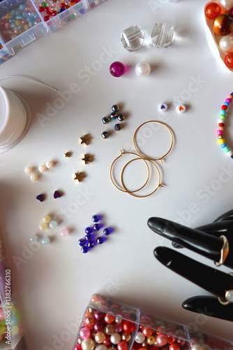 Obraz na płótnie Hand figurine, colorful friendship bracelets, necklaces, various beads and DIY supplies on the table. Making jewelry at home. Flat lay. w salonie