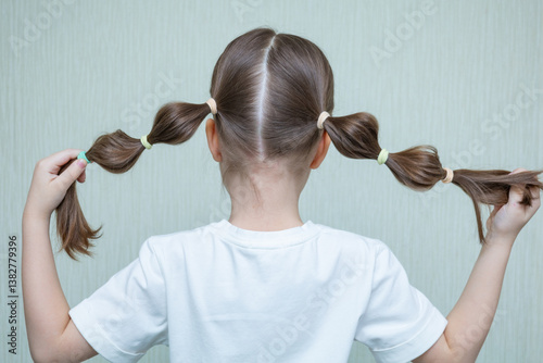 Young woman with long, dark blonde hair pulled back in a low ponytail. Casual hairstyle. Sporty hairstyle. Running hairstyle.