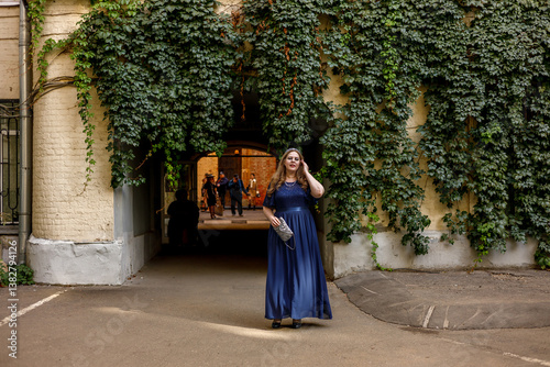 Obraz na płótnie Woman in a long blue dress in the garden. w salonie