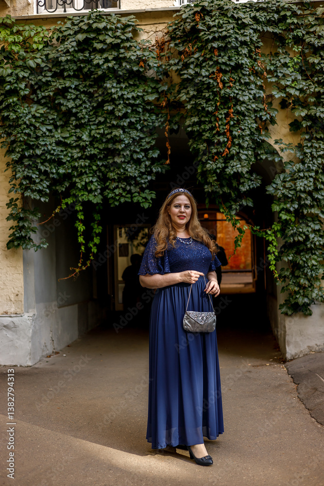 Woman in a long blue dress in the garden.