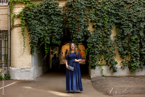 Woman in a long blue dress in the garden.