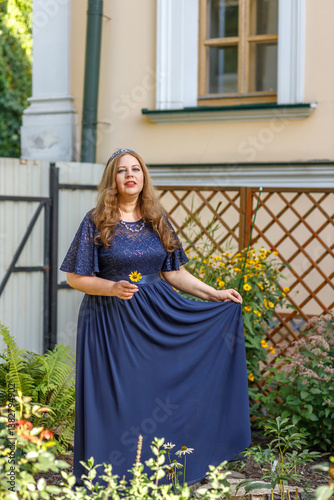Obraz na płótnie Woman in a long blue dress in the garden. w salonie