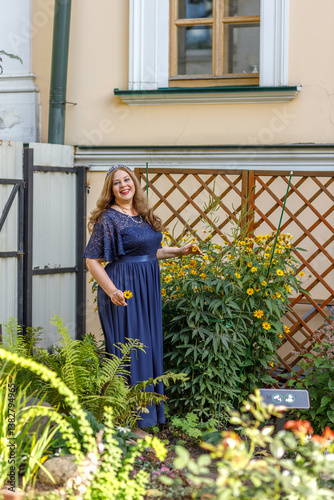 Obraz na płótnie Woman in a long blue dress in the garden. w salonie