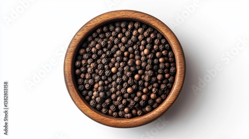 A top-down view of black peppercorns in a wooden bowl on a white backdrop