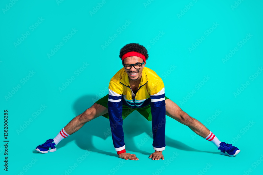 Playful retro-inspired workout with a smiling man in vibrant vintage sportswear against a turquoise studio background Playful retro-inspired workout with a smiling man in vibrant vintage sportswear against a turquoise studio background
