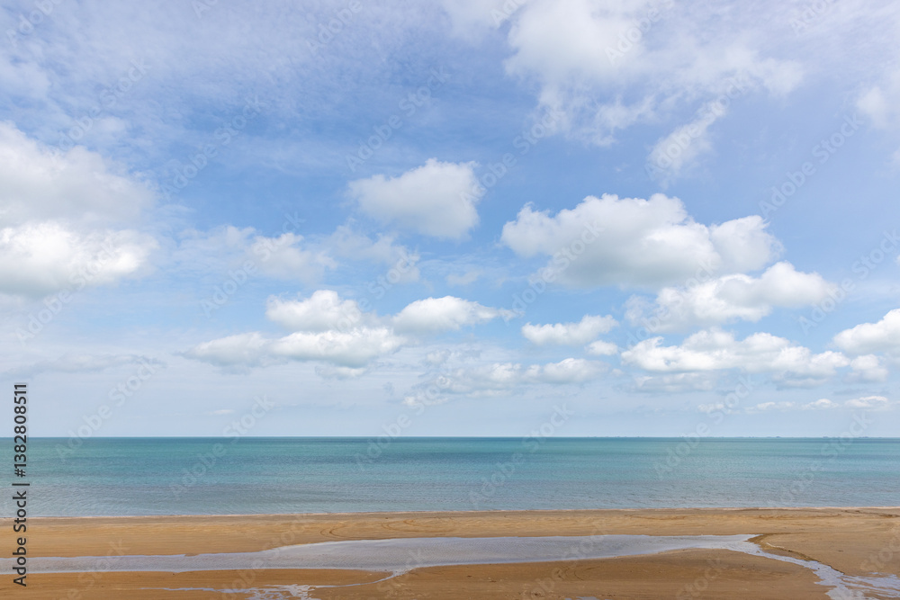 Peaceful seascape with a sandy shoreline, calm ocean waters and sky