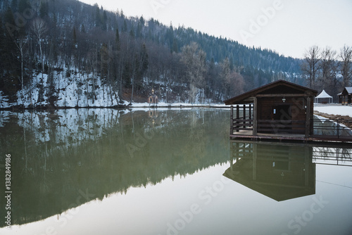 Photography A quaint and charming small wooden house is gently resting on a dock situated ri