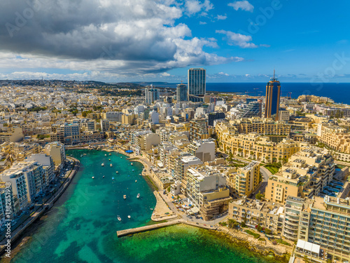 Drone aerial view of St. Julian's city, coast road, waterfront, buildings. Malta island