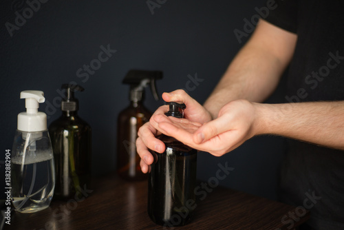 Hands press on the massage oil dispenser