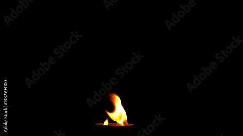 Flames are burning in a bowl isolated on a black background. Concept of particles, sparkles, flame and light