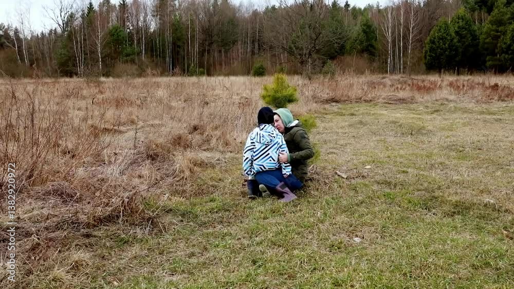 Children playing in a sunny field, joyfully embracing a small evergreen tree in nature Children playing in a sunny field, joyfully embracing a small evergreen tree in nature