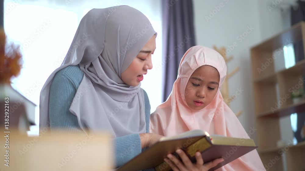 Asian muslim woman reading and reviewing the holy Koran book with her daughter.