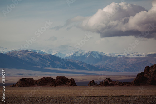 Obraz na płótnie A rugged landscape with snow-capped peaks fading into the blue sky in Mongolia, embodying raw beauty and vastness. w salonie