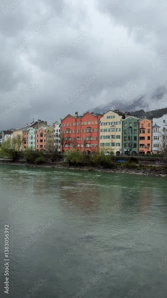 Scenic view of a riverside with residential buildings and greenery on a cloudy day, creating a tranquil urban landscape. Innsbruck Austria Scenic view of a riverside with residential buildings and greenery on a cloudy day, creating a tranquil urban landscape. Innsbruck Austria
