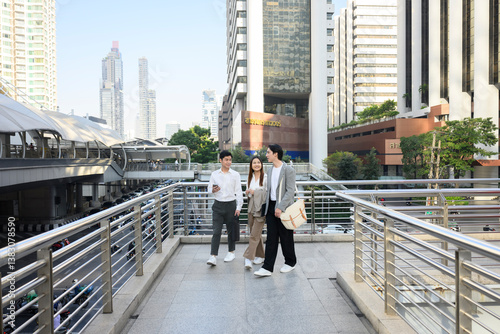 Photography Young professionals walking and talking on modern city footbridge