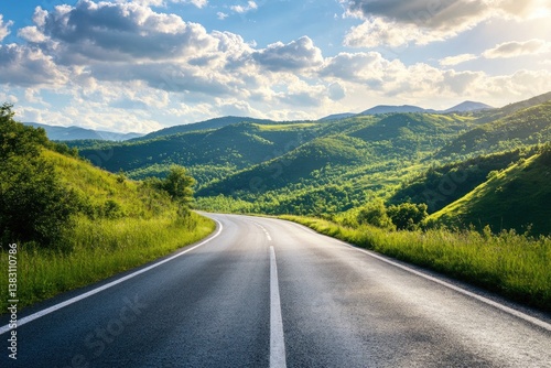 Winding road through verdant hills under a bright sky photo
