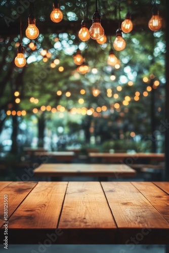 Rustic wooden table with hanging light bulbs creating warm ambience in a blurred outdoor restaurant setting with green foliage